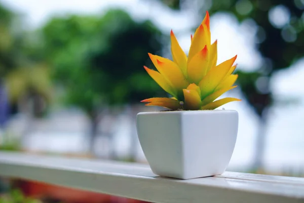 Flor artificial en maceta blanca decorar en el balcón con fondo exterior borroso —  Fotos de Stock