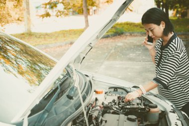 Cep telefonu kullaranarak ve yardım ederken aşağı kırılmış araba için arama Asyalı kadın eklendi renkli filtre ve vintage style 