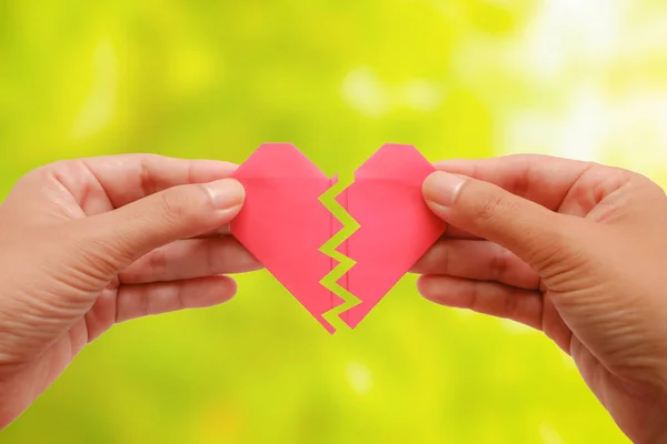 Mano Sosteniendo Papel Rojo Corazón Roto Sobre Fondo Natural Verde — Foto de Stock