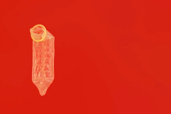 Männliches Kondom Auf Rotem Hintergrund Mit Kopierraum Für Verhütung Und — Stockfoto
