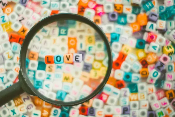 Wortliebe auf der Lupe mit Alphabet-Buchstabenperlen bac — Stockfoto