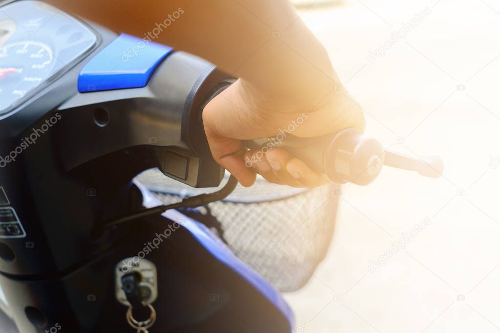 Selective focus of man's hand riding motorcycle on blurred concr