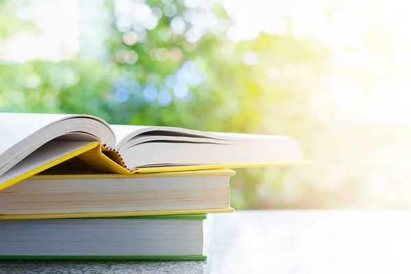 Doğal yeşil arka plan bulanık güneş ışık etkisi ve kopya alanı eğitim ve öğrenme kavramı ile ilgili kitap yığını