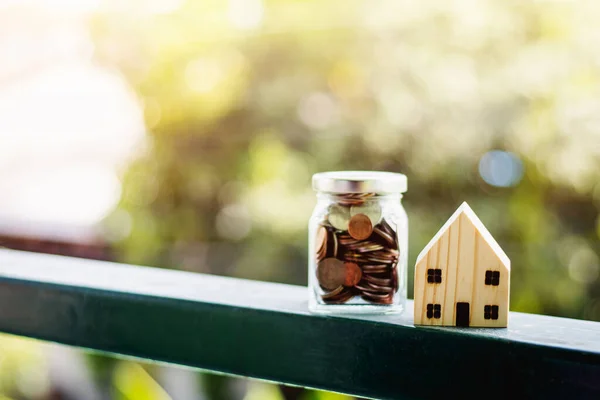 Houten Huis Model Met Geld Munten Glazen Pot Tegen Wazig — Stockfoto