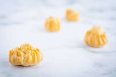 Lezzetli ekinazor vanilya kremi, kremayla dolu choux hamur, beyaz mermer arka planda ev yapımı fırın atıştırmalık konsepti için.