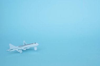 Araç ve ulaşım konsepti için mavi arka plan üzerinde beyaz uçak modeli