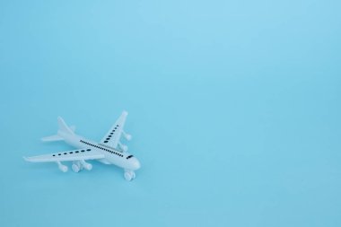 Araç ve ulaşım konsepti için mavi arka plan üzerinde beyaz uçak modeli