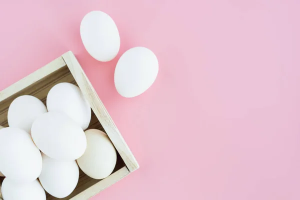 健康食品概念的粉色背景木制托盘中的白蛋 — 图库照片