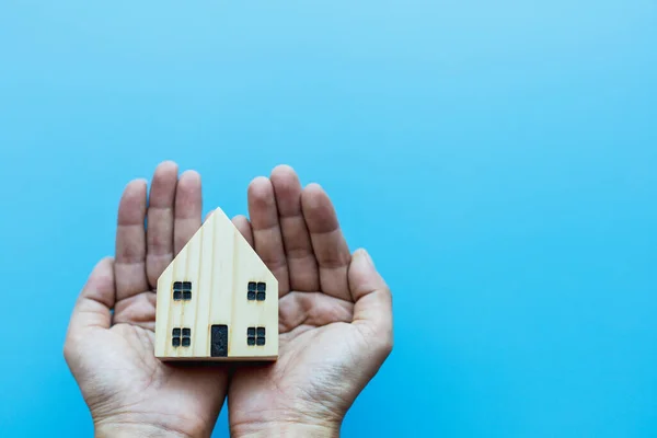 Mano Sosteniendo Modelo Casa Madera Sobre Fondo Azul Para Auto — Foto de Stock