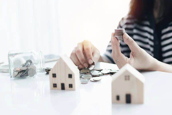 Kadın eli, planlama, konut ve emlak finansal konsepti için para biriktiriyor