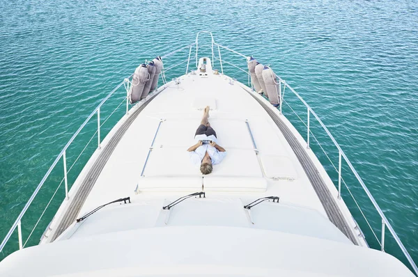 Człowiek leżący na pokładzie jachtu — Zdjęcie stockowe