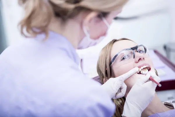 Woman receiving hardening of dental filling — Stock Photo, Image