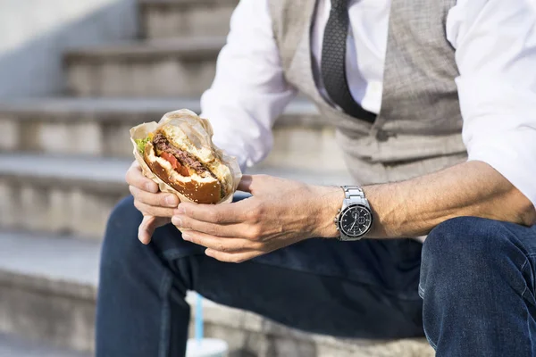 ハンバーガーを食べる実業家 — ストック写真