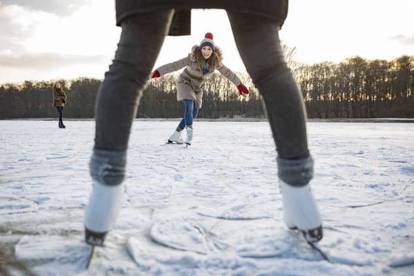 Woman ice skating on frozen lake — Stock Photo, Image