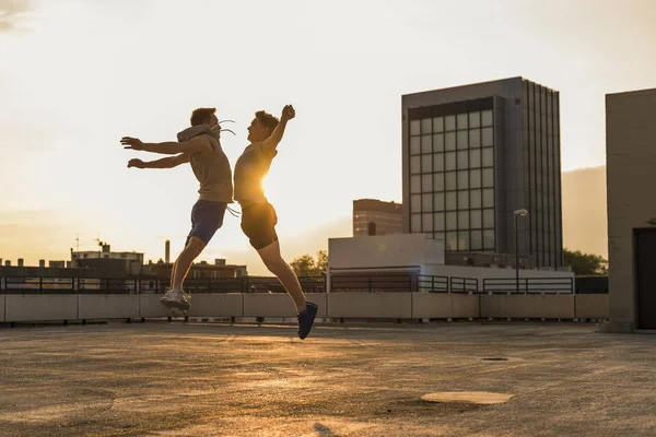 Friends jumping for joy at sunset — Stock Photo, Image