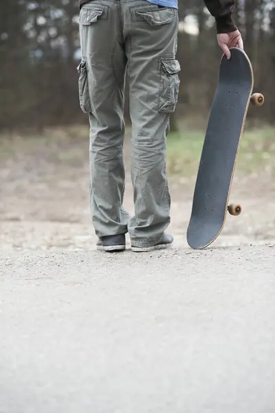 Man standing and holding skateboard — Stock Photo, Image
