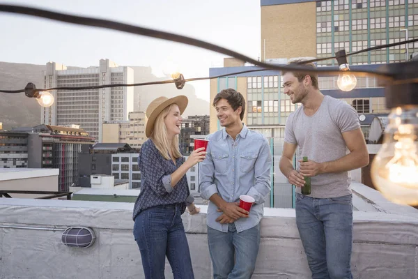 Friends talking on rooftop party — Stock Photo, Image
