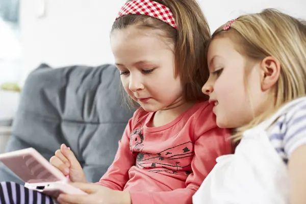 Two little girls sitting on couch — Stock Photo, Image