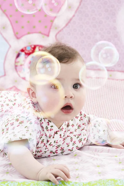 Bébé fille regarder savon bulles — Photo