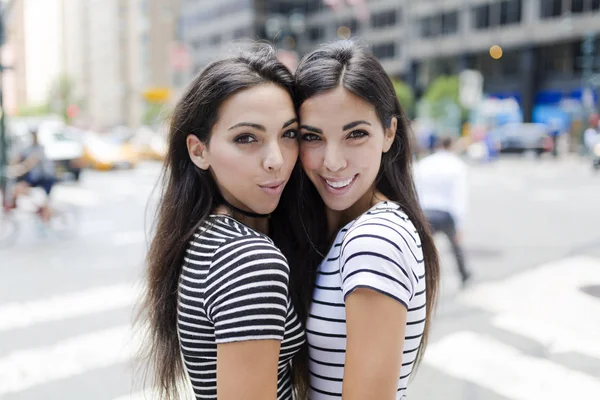 Twin sisters standing face to face — Stock Photo, Image