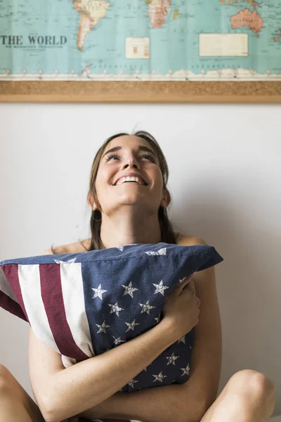 Giovane Donna Che Abbraccia Cuscino Con Bandiera Americana Casa — Foto Stock