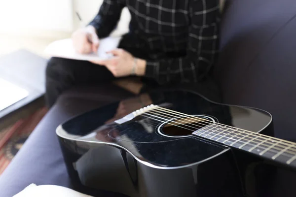 Άνθρωπος γραφή σημειώσεις, κιθάρα στο προσκήνιο — Φωτογραφία Αρχείου