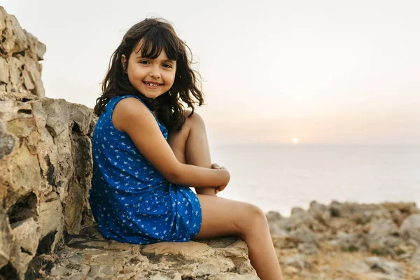Portrét Malé Radostné Holčičky Sedící Skále Moře Při Západu Slunce — Stock fotografie