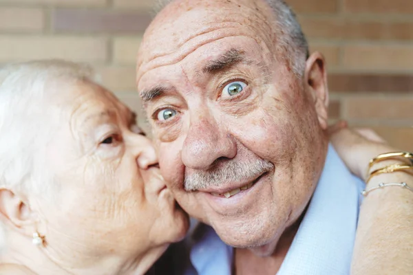 Homem Sênior Puxando Cara Engraçada Enquanto Sua Esposa Beijando — Fotografia de Stock