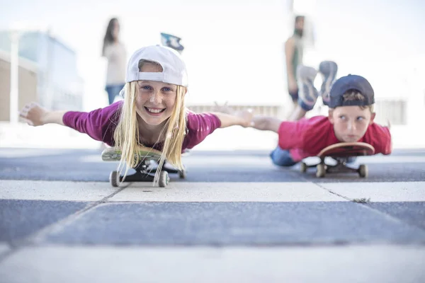 Retrato Los Niños Sonrientes Skateboarding Calle Acostado Vientre — Foto de Stock