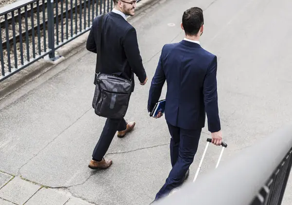 Businessmen walking with wheeled luggage — Stock Photo, Image