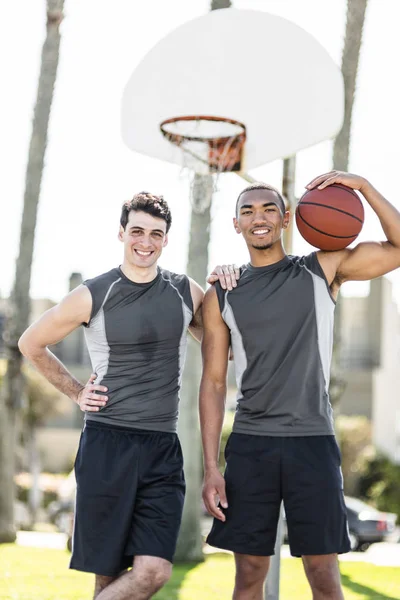户外篮球场上两名微笑的年轻人的肖像 — 图库照片