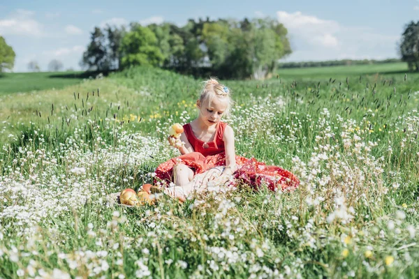 Menina sentada no prado da flor — Fotografia de Stock