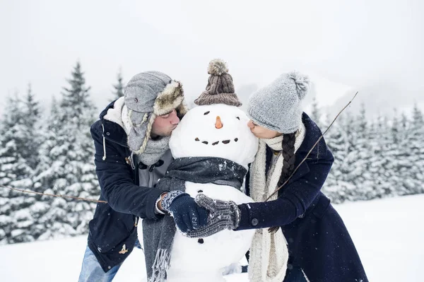 Feliz Caucásico Pareja Besos Snowman Juntos —  Fotos de Stock