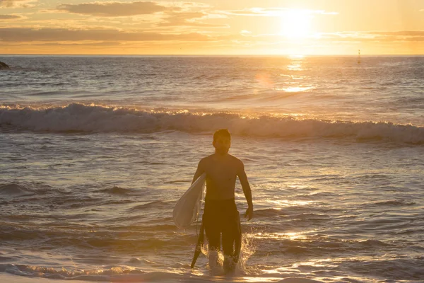 Серфер Восходе Солнца Гидрокостюме Доской Серфинга Пляже — стоковое фото