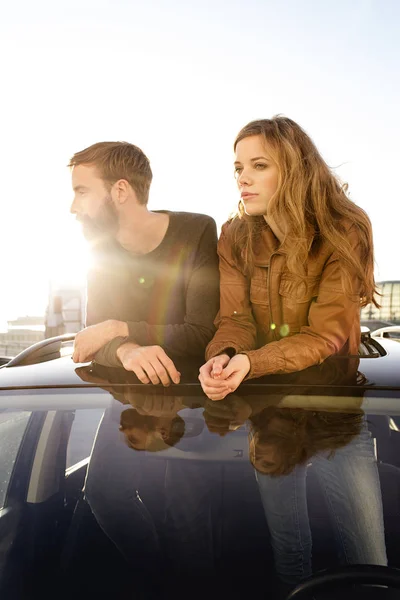 Couple looking through sunroof of car — Stock Photo, Image