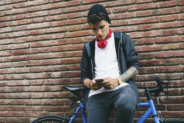 Подросток Фиксированным Велосипедом Смс Кой Смартфоне Опирающимся Кирпичную Стену — стоковое фото
