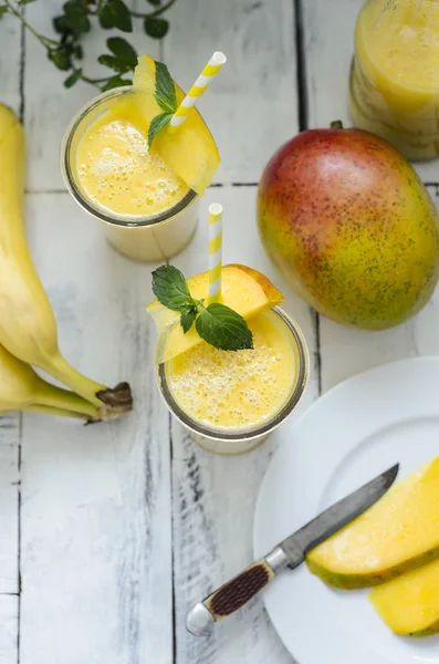 Dwie Szklanki Smoothie Bananowy Mango Białej Powierzchni Drewnianych Składników — Zdjęcie stockowe