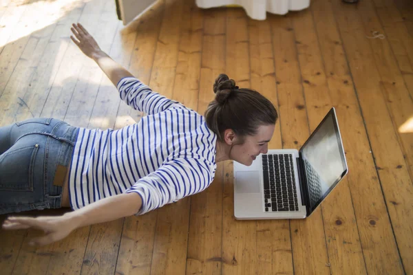 Young Woman Home Lying Wooden Floor Laptop Pretending Fly — Stock Photo, Image