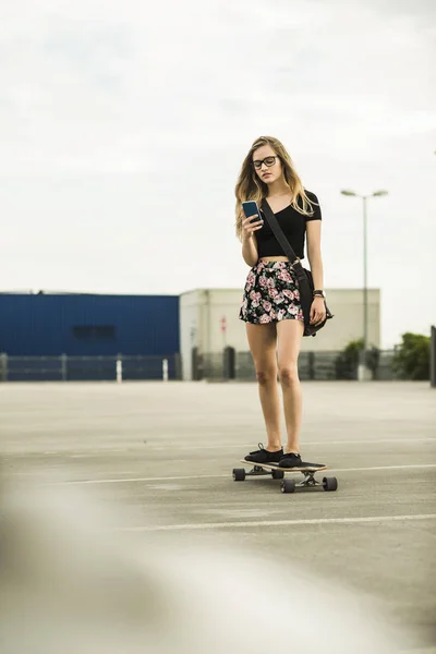 Teenage Girl Riding Skateboard Looking Cell Phone — Stock Photo, Image