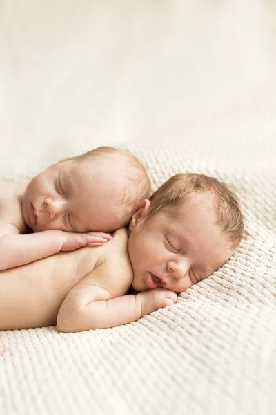 拥抱新生双胞胎睡在毯子上 — 图库照片