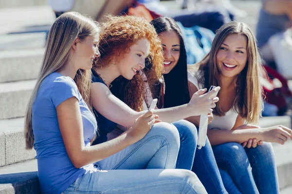 Quatro Amigos Sentados Juntos Passos Olhando Para Smartphone — Fotografia de Stock