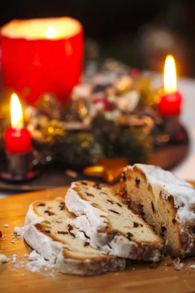 Sliced Stollen and lighted candles — Stock Photo, Image