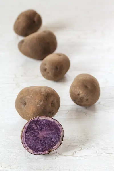 Batatas vermelhas inteiras e cortadas pela metade — Fotografia de Stock