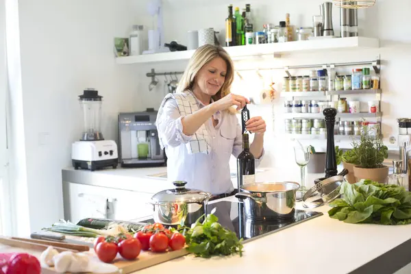 Frau öffnet eine Flasche Wein — Stockfoto