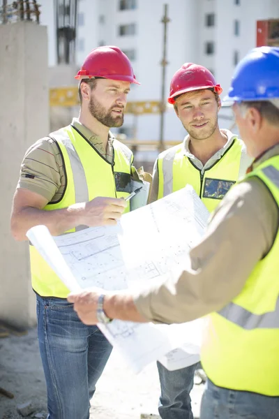 Bauarbeiter Diskutieren Baupläne Auf Baustelle — Stockfoto