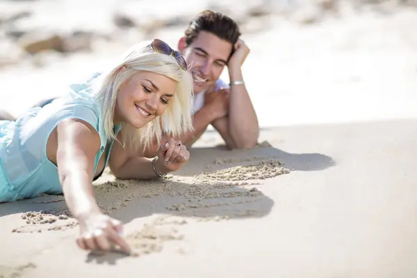 Giovane Coppia Sdraiata Sulla Spiaggia Disegno Nella Sabbia — Foto Stock