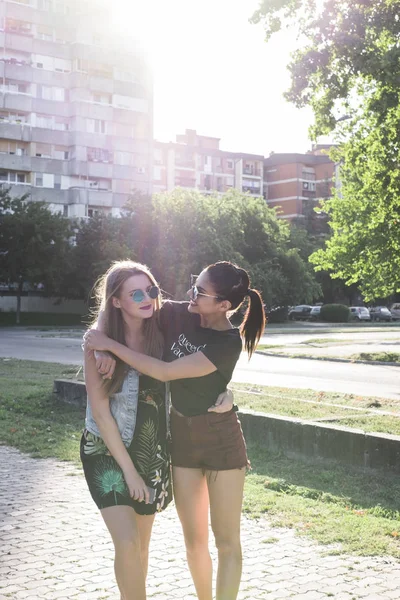 两个女朋友站在街上的背光 — 图库照片
