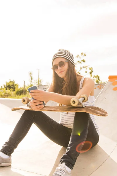 Smartphone Kullanarak Bir Skatepark Oturan Gözlüklü Genç Paten Yatılı Portresi — Stok fotoğraf