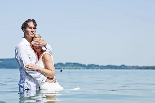 巴伐利亚 Tegernsee 新婚夫妇站在湖里 男人屏蔽女人的眼睛 — 图库照片