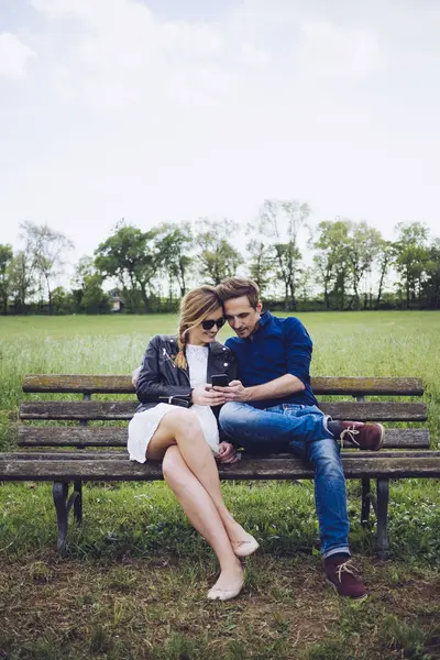 Casal Sentado Banco Olhando Para Smartphone — Fotografia de Stock